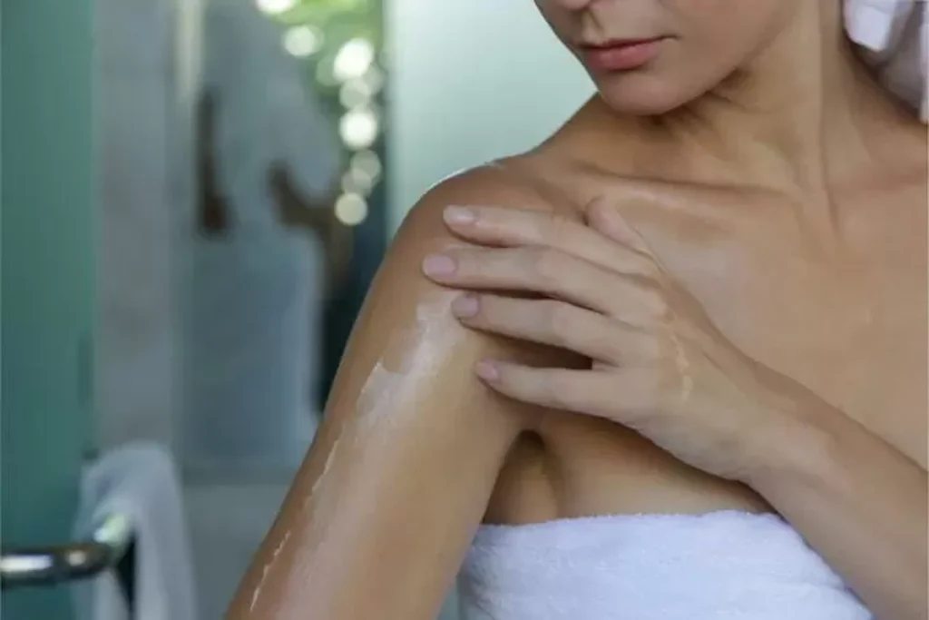 Mulher passando óleo no corpo