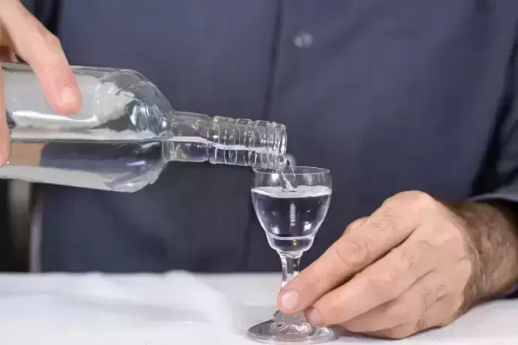 Homem colocando gin no copo