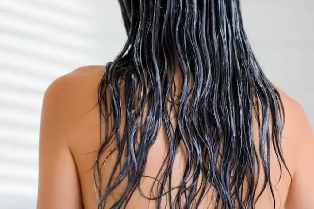 Mulher de costas e creme no cabelo